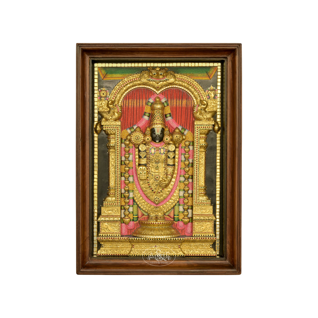 A Tanjore painting depicting Tirupathi Balaji, featuring rich gold colors, intricate handwork, and the deity standing in a temple arch, framed in a wooden frame.