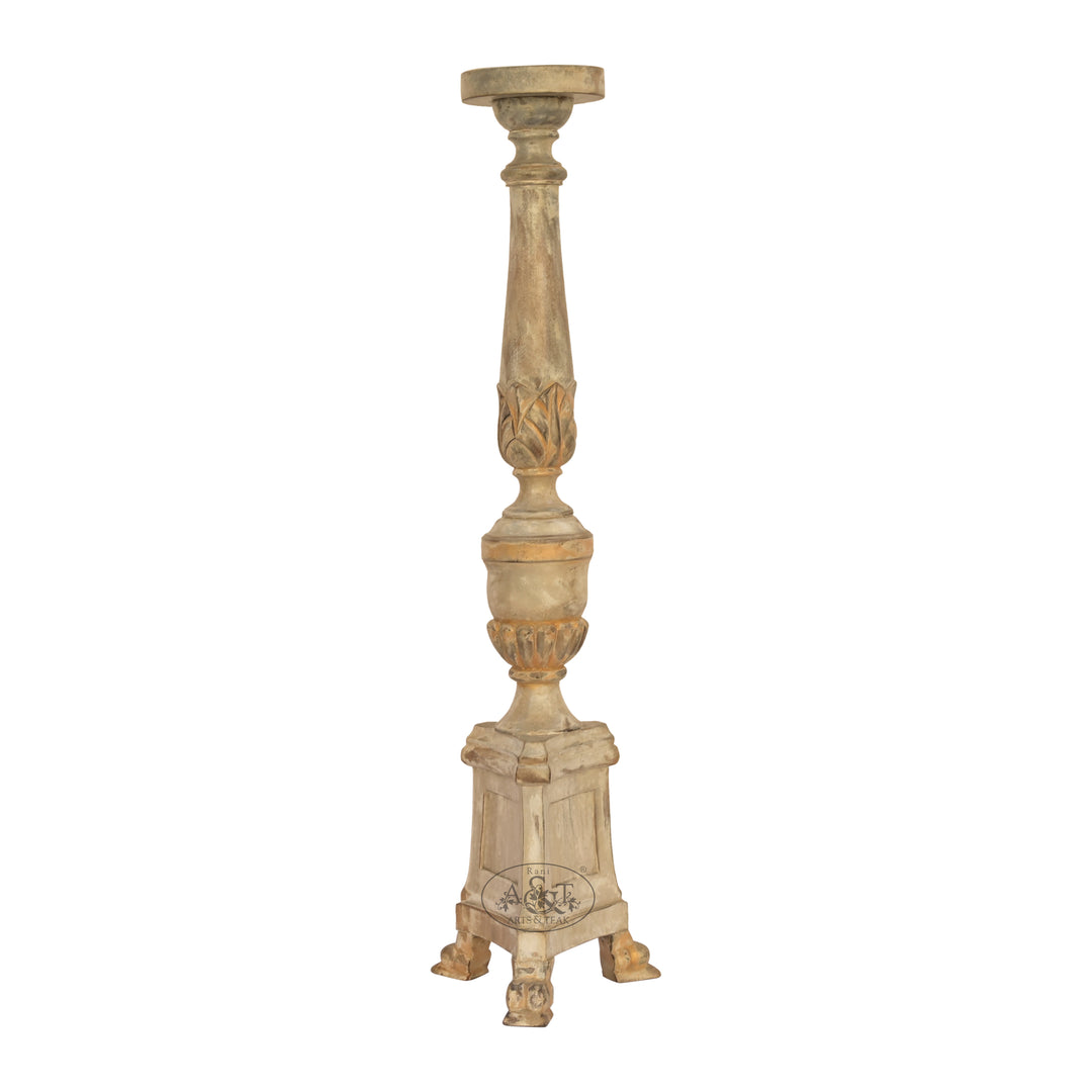 A hand-carved wooden candle stand with intricate details and a polychrome finish.