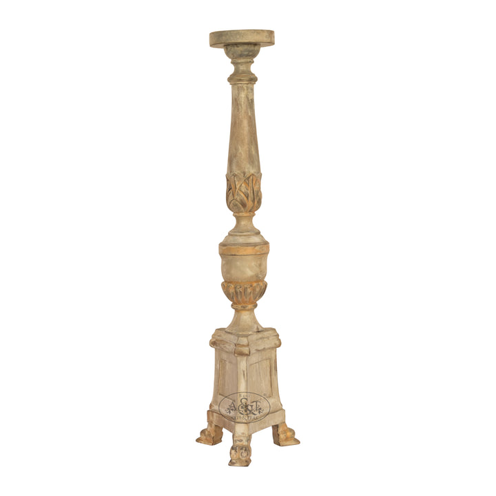 A hand-carved wooden candle stand with intricate details and a polychrome finish.