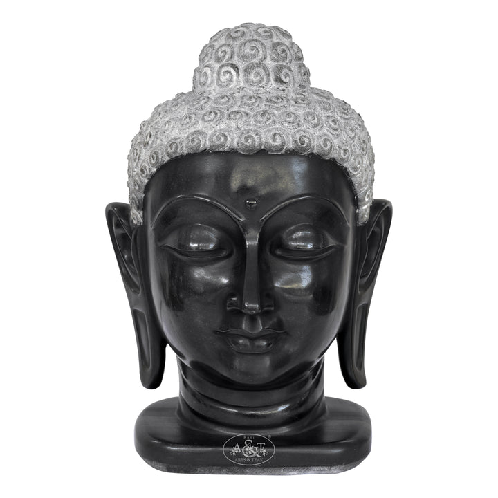 Black Buddha head statue with gray hair on a white background