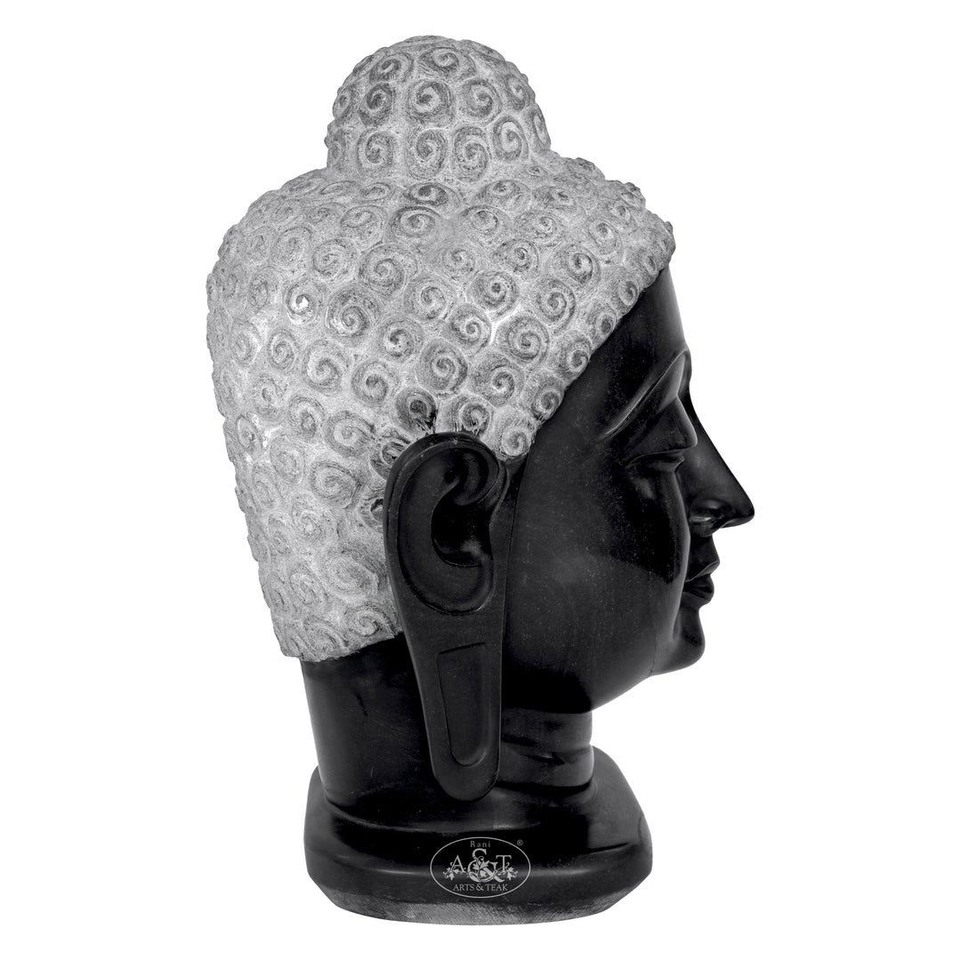 Black marble Buddha head sculpture with intricate patterns on a white background