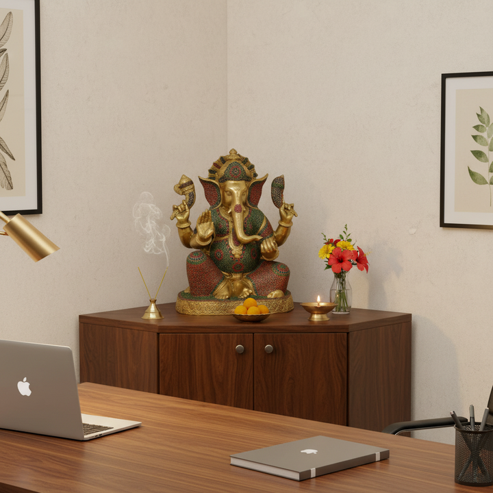 Decorative statue of a神灵 on a wooden cabinet with a laptop and chair in a room.